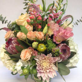 Mixed bouquet of pink, peach, and white flowers in a vase