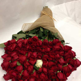 Large bouquet of red roses wrapped in burlap with one white rose