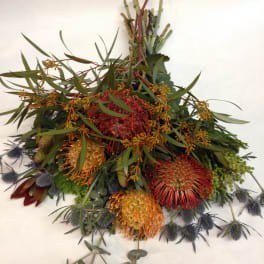 Mixed bouquet with red, orange, and yellow pincushion-like blooms