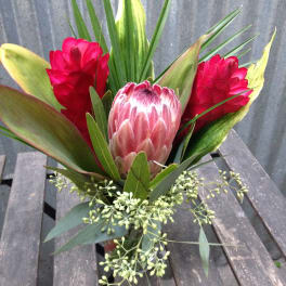 Tropical bouquet with pink protea and red ginger flowers