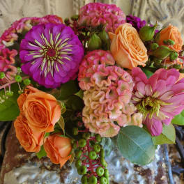 Bouquet of orange roses, pink zinnias, and pink cockscomb