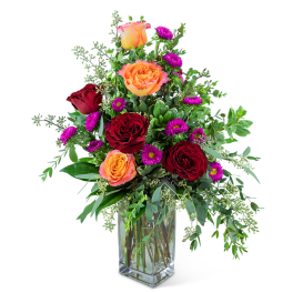 Mixed bouquet of red and orange roses in a clear glass vase