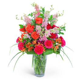 Bright mixed bouquet in a clear glass vase with pink and orange flowers
