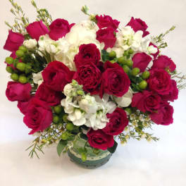Bouquet of red roses and white flowers in a glass vase
