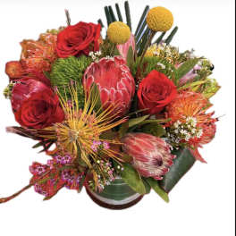Mixed bouquet with red roses and pink protea in a vase