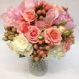 Pink and white rose bouquet in a textured glass vase
