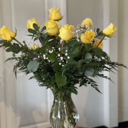 Yellow roses arranged in a clear glass vase