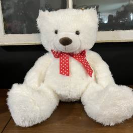White teddy bear with a red polka-dot ribbon