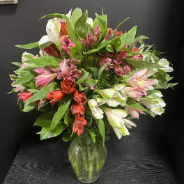 Mixed pink, white, and red flowers in a clear glass vase