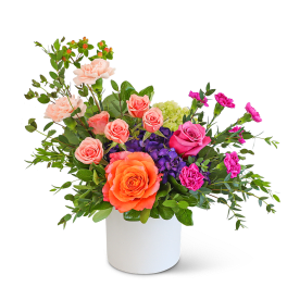 Mixed bouquet of roses, carnations, and hydrangeas in a white vase