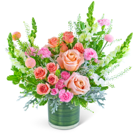 Peach and pink roses in a green glass vase