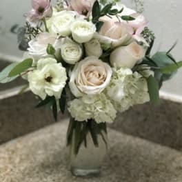 Bouquet of pale roses and white blooms in a glass vase