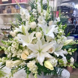 White lilies and roses in a white vase arrangement