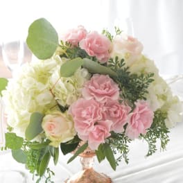 Pink and white roses arranged in a glass vase