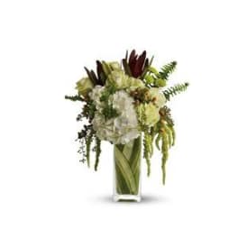 White and green floral arrangement in a tall glass vase