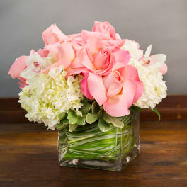 Pink roses and white hydrangeas in a square glass vase