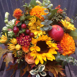 Autumn bouquet with sunflowers, marigolds, and a red apple