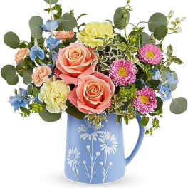 Mixed bouquet in a blue floral pitcher vase