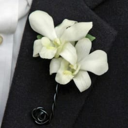 White orchid boutonniere on a dark suit jacket