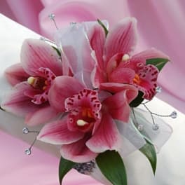 Pink orchid bouquet with white ribbon and decorative beads
