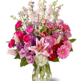 Mixed pink and purple flower bouquet in a clear glass vase