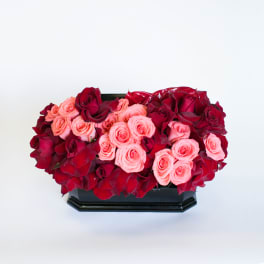 Red and pink roses arranged in a black rectangular vase