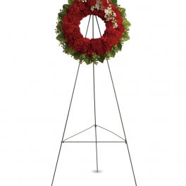 Red floral wreath on a metal easel stand