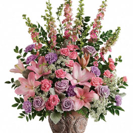 Pink and lavender floral arrangement in an ornate brown vase