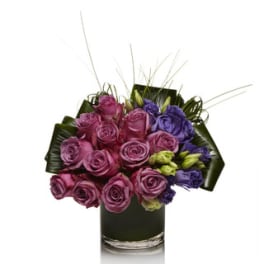Pink and purple roses arranged in a glass vase