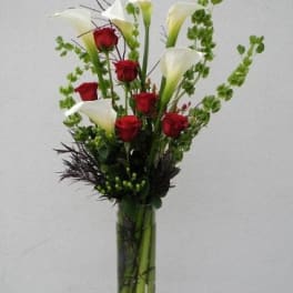 Tall vase arrangement with red roses and white calla lilies