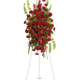 Tall red floral standing arrangement on a white easel