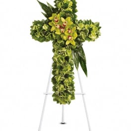 Green floral cross on a stand with yellow orchids