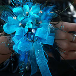 Blue floral wrist corsage with ribbon and feathers