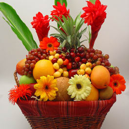 Fruit basket with red flowers and assorted fruit in a wicker basket