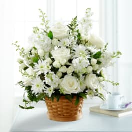 White roses and daisies arranged in a woven basket