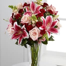 Bouquet of pink lilies and roses in a clear glass vase