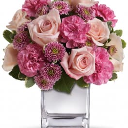 Pink roses and carnations in a clear glass vase