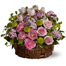 Pink and white flowers arranged in a wicker basket