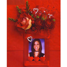 Red rose arrangement above a framed portrait with heart accents