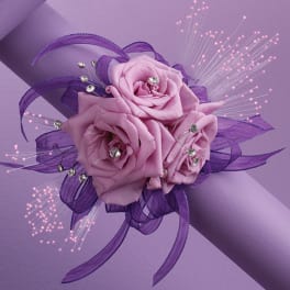 Pink rose corsage with purple ribbon and sparkly accents