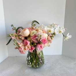 Pink and white flower arrangement in a clear glass vase