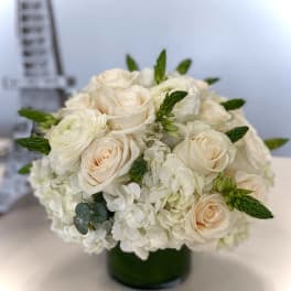 Cream roses and white hydrangeas in a dark green vase