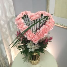 Pink carnation arrangement in a gold vase with white flowers
