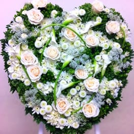 Heart-shaped floral wreath with pale roses and white flowers