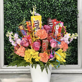 Candy bouquet with pink and yellow flowers in a white pot