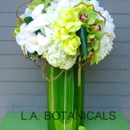 Tall bouquet of white and lime-green flowers in a green vase