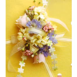 Pastel floral corsage with ribbon on a yellow background