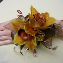 Yellow orchid corsage with leopard-print ribbon on a wrist
