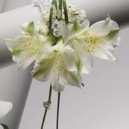 White alstroemeria corsage with crystal accents on a white ribbon