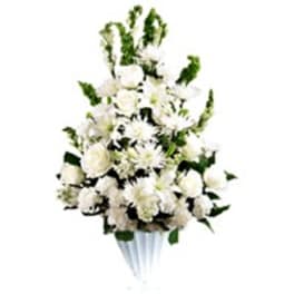 White floral spray in a white vase with green accents